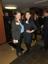 Two women at poker tournament standing together and smiling at camera