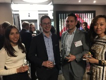 People at formal event in business attire smiling at camera