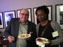 People at formal event holding dinner plates and smiling at camera