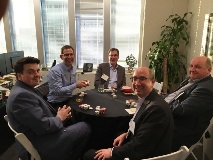 Group of people at poker table smiling at camera