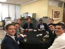 Group of people at poker table smiling at camera