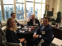 People sitting around poker table smiling at camera
