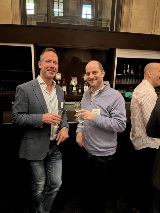 Two people standing at bar and smiling at camera