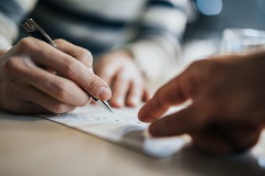 Lawyer showing a client where to sign