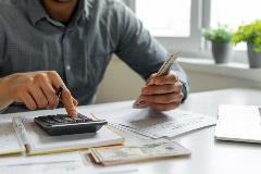 A man calculating taxes and balancing books