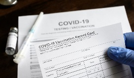 Covid 19 vaccination form with syringe on the table