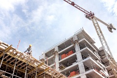 Crane towering over uncompleted building