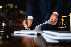 A lawyer looking over a contract and signing