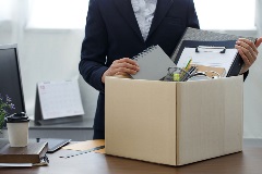 Person with packed box of desk supplies